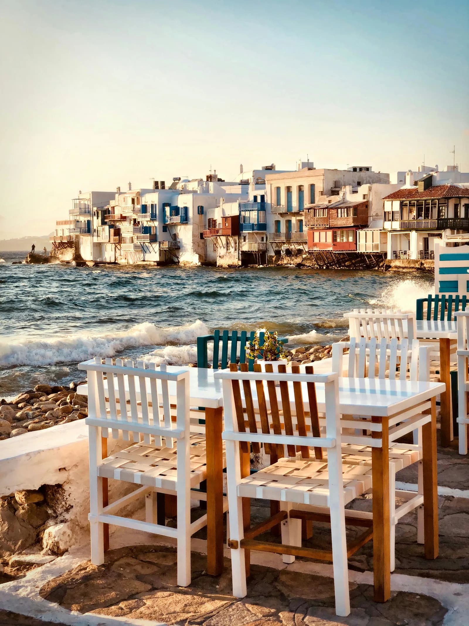Tables set out by the water in front of the Little Venice houses on Mykonos.
