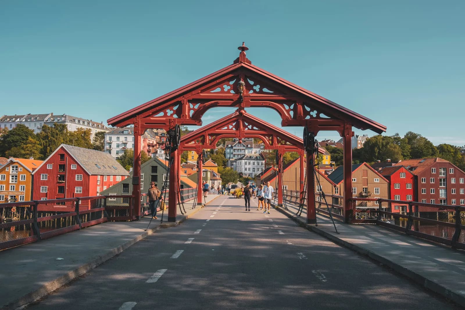 Trondheim's Gamle Bybro, the old town bridge with red wooden portals, the colourful Bakklandet wharf houses along the Nidelva behind.